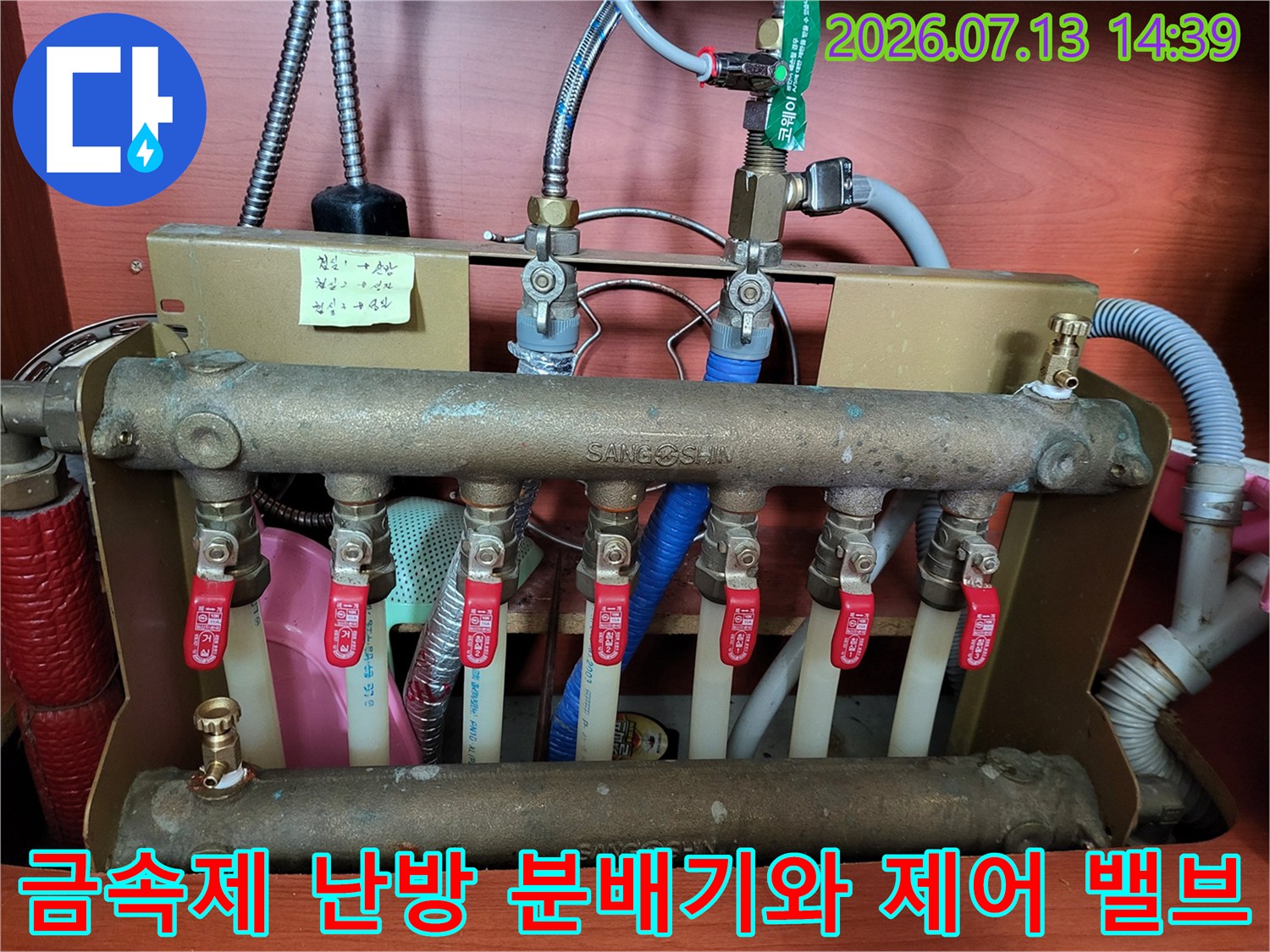 여러 개의 빨간색 핸들 밸브가 장착된 금속제 보일러 분배기 사진