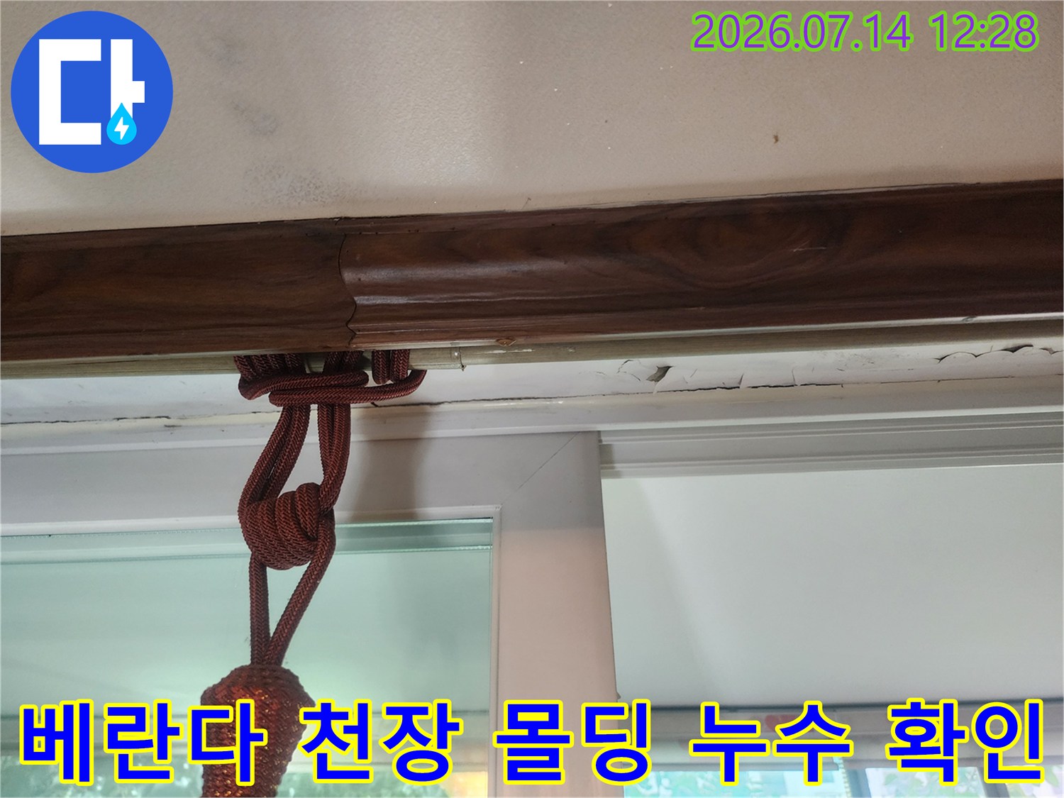 목재 몰딩 부위와 에어컨 드레인 배수 호스가 노출된 베란다 천장 모습