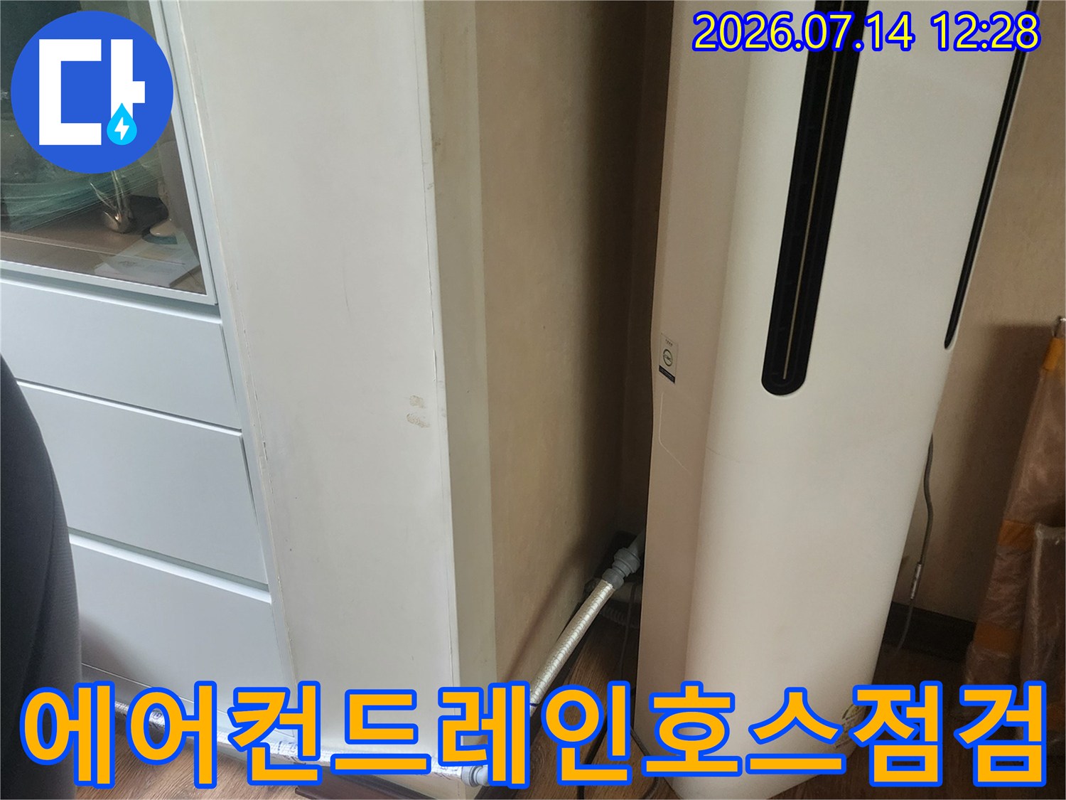베란다에 설치된 에어컨과 노출된 배수 호스 점검 모습
