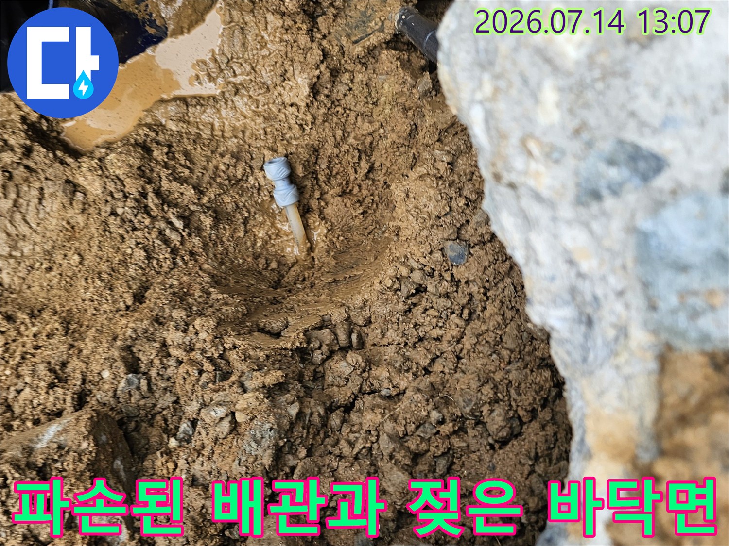 물에 잠긴 토양을 지나며 노출된 파손된 배관의 누수 구간