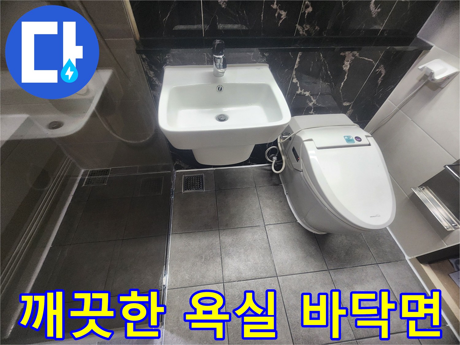 완료된 욕실의 변기와 세면대 주변 타일 마감 모습입니다.