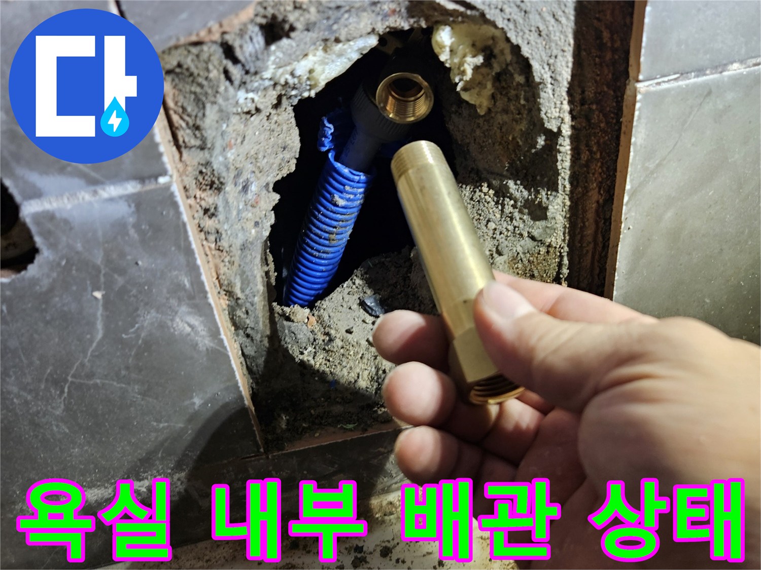 욕실 타일 절개 후 노출된 파란색 배관과 수전 연결 부위 모습