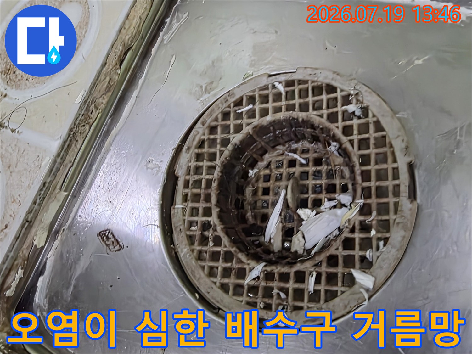 화장실 바닥 배수구의 스테인리스 망에 찌꺼기가 쌓여 있는 근접 사진