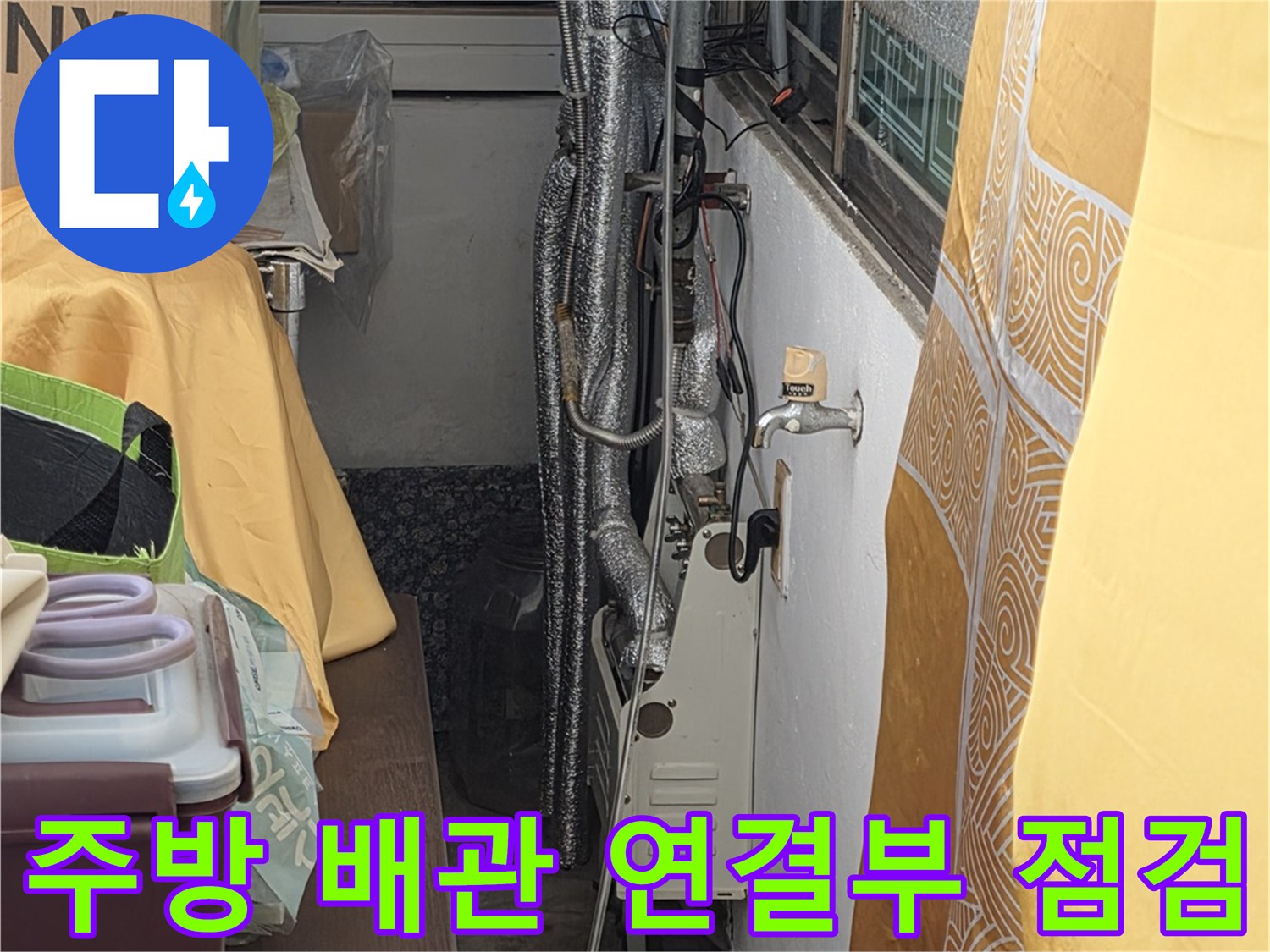 싱크대 아래 보온재로 감싸진 배관들의 연결 지점을 세밀하게 관찰하는 장면입니다.