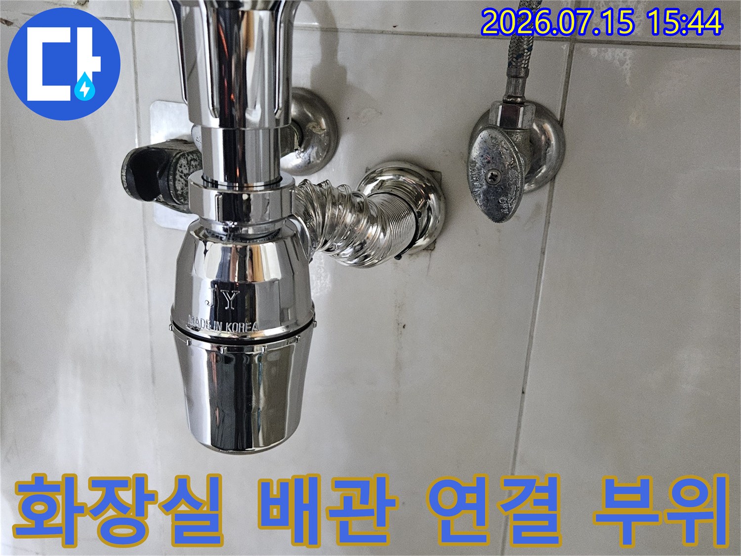 금속 재질의 세면대 하부 배관과 파이프 연결부를 근접 촬영한 사진