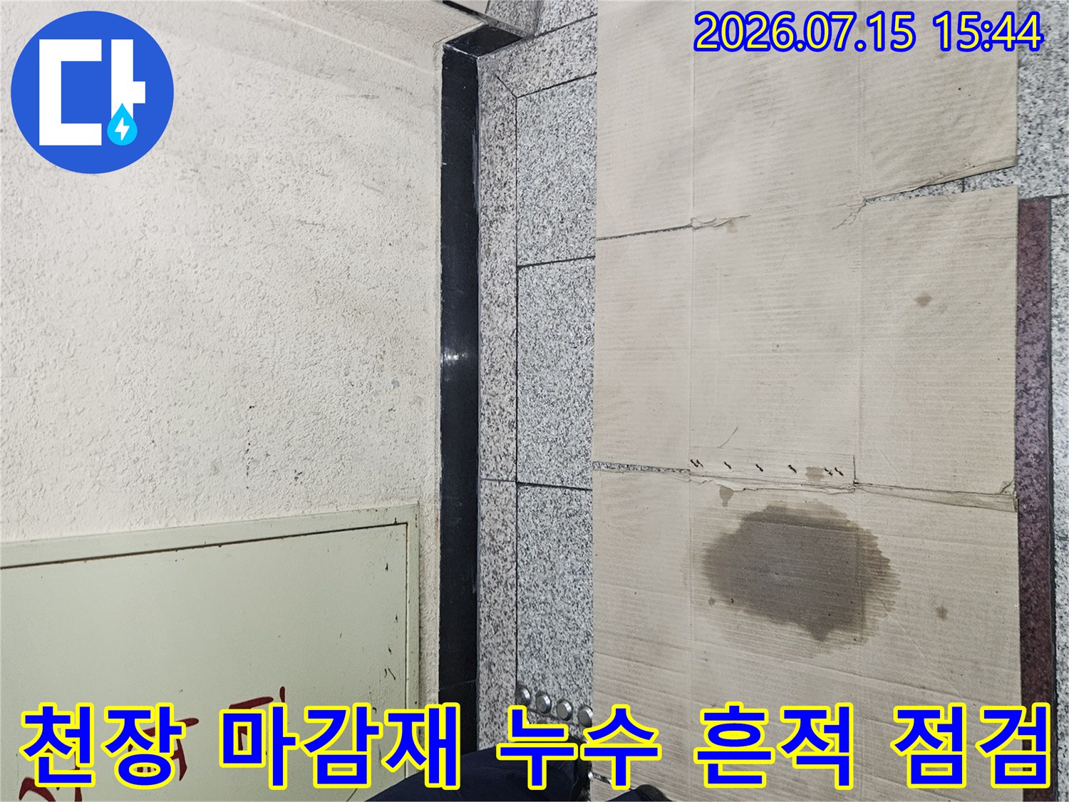 노란색 얼룩이 진 천장 판넬과 작업용 신발이 위치한 누수 피해 현장