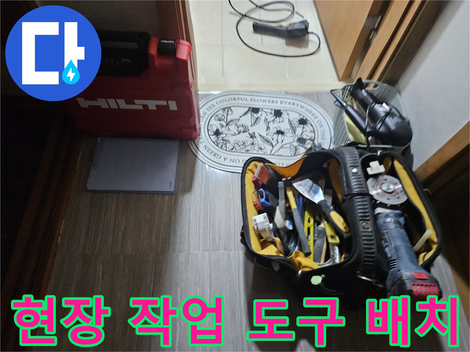 바닥에 놓인 붉은색 장비 케이스와 각종 배관 수리 공구 세트