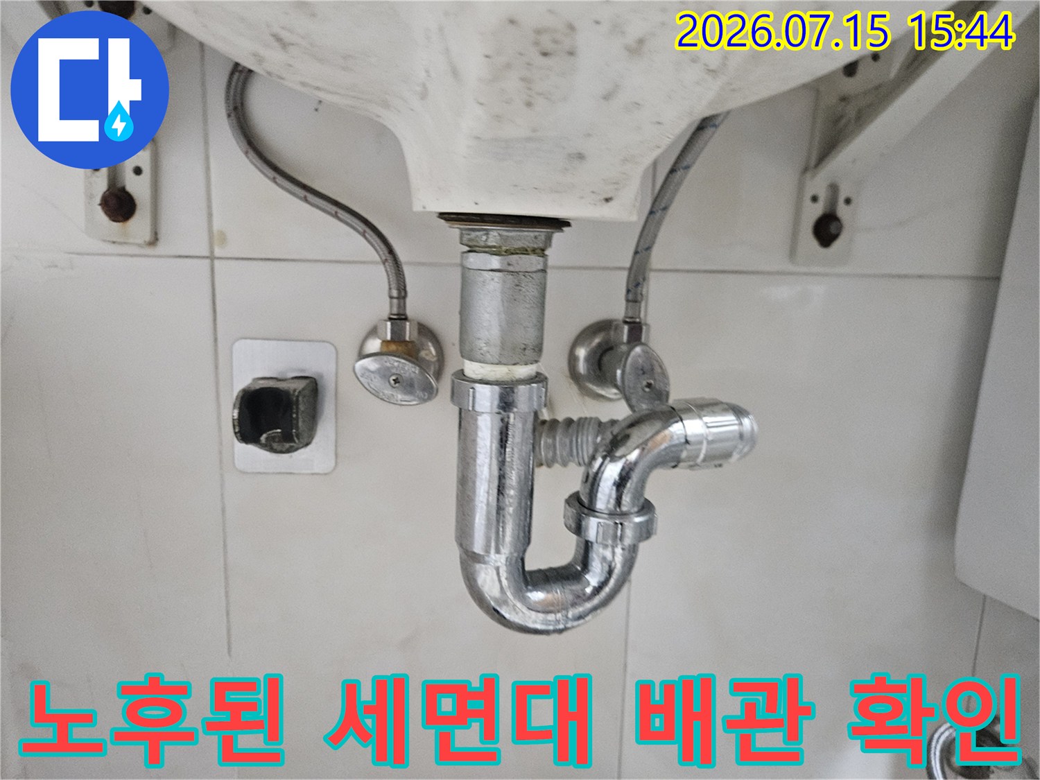 세면대 하부 트랩과 연결 호스의 노출 상태를 촬영한 사진입니다.