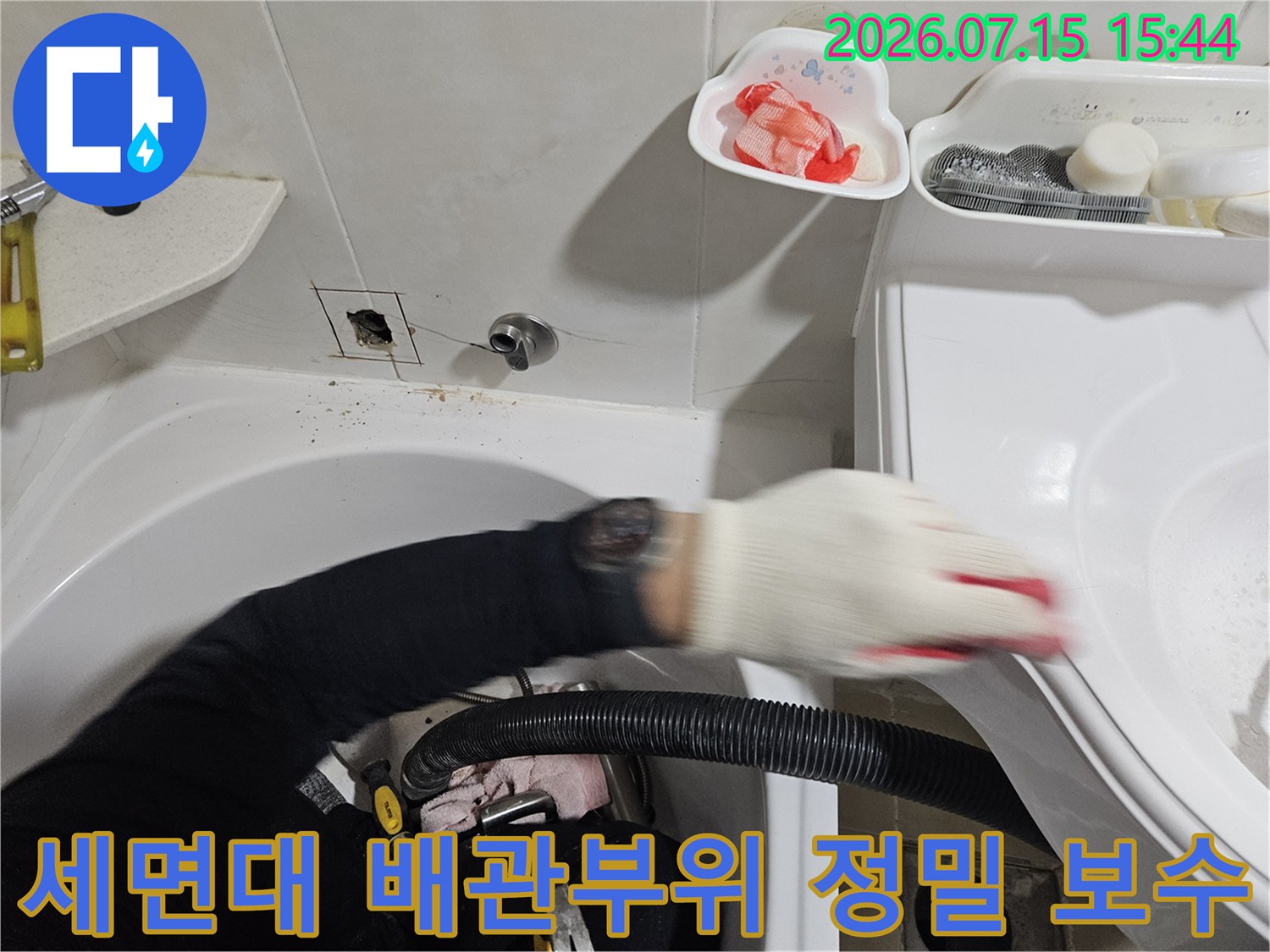 전문 장비를 사용하여 세면대 아래쪽의 낡은 배관 연결부를 교체하는 현장 모습