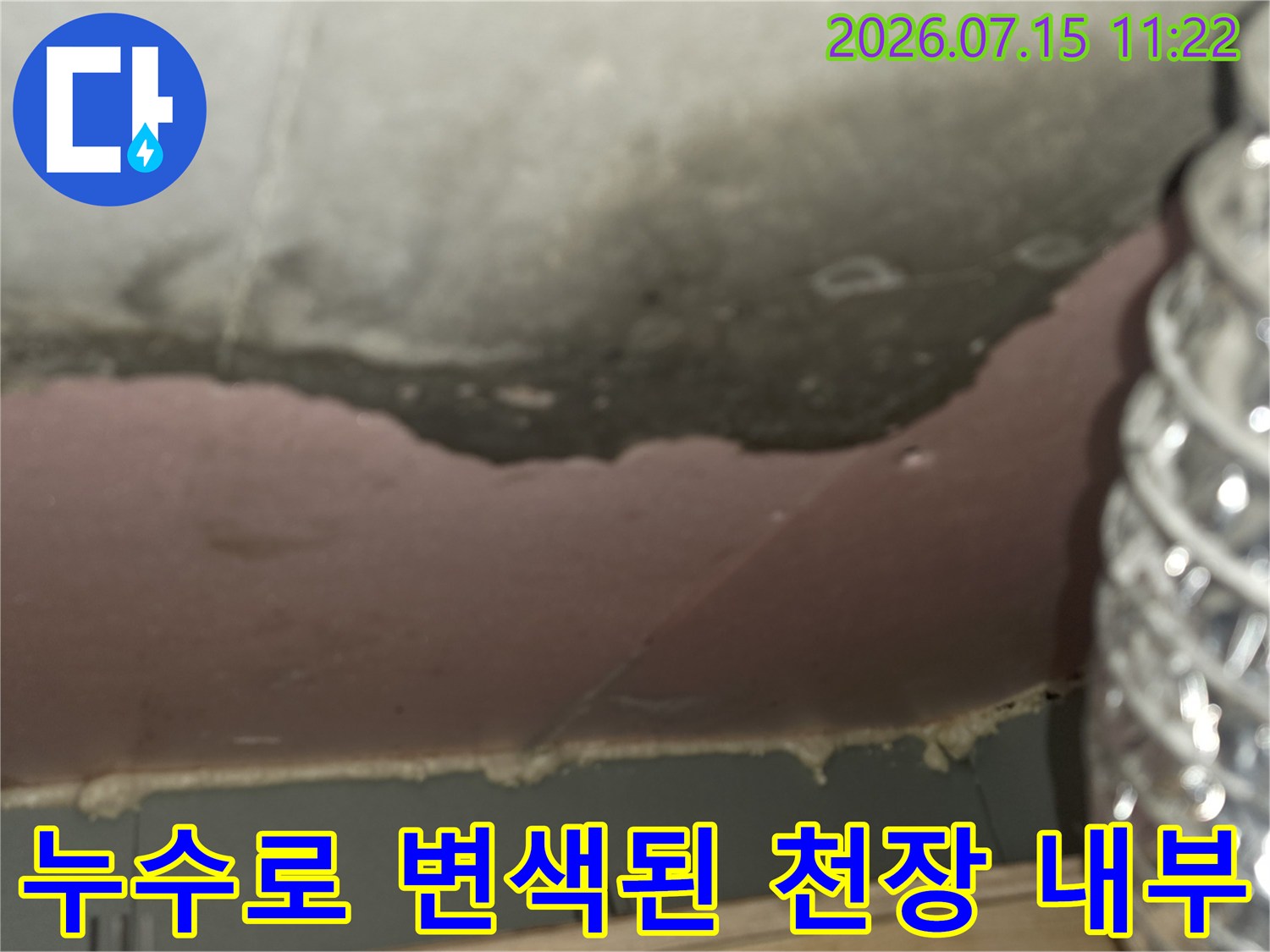 습기로 인해 검게 오염된 콘크리트 천장-옆에 위치한 은색 배관