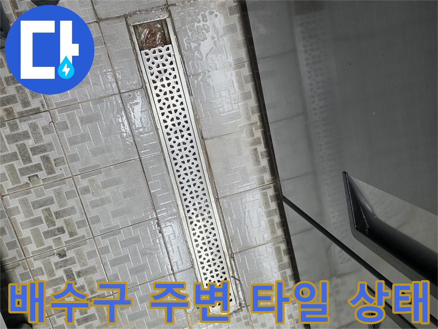 식당 주방 배수구 트렌치 덮개와 인근 타일 바닥의 습기 상태를 촬영한 사진