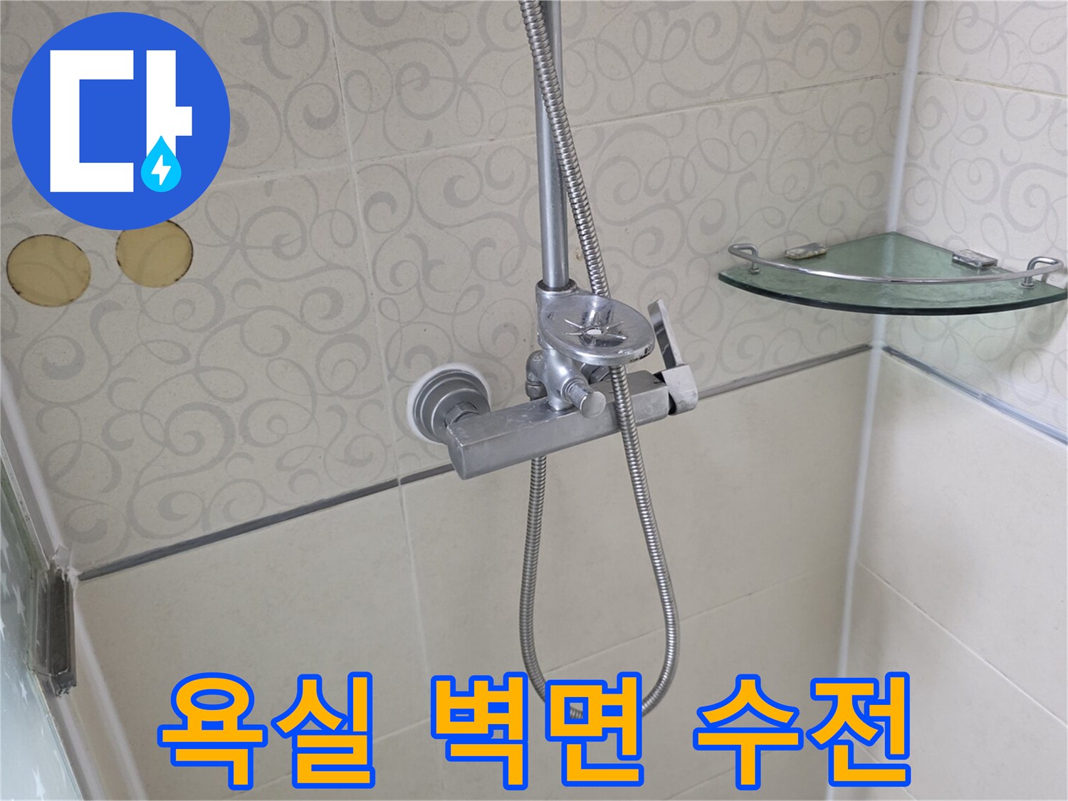샤워기 수전과 유리 선반이 있는 화장실 벽면 사진