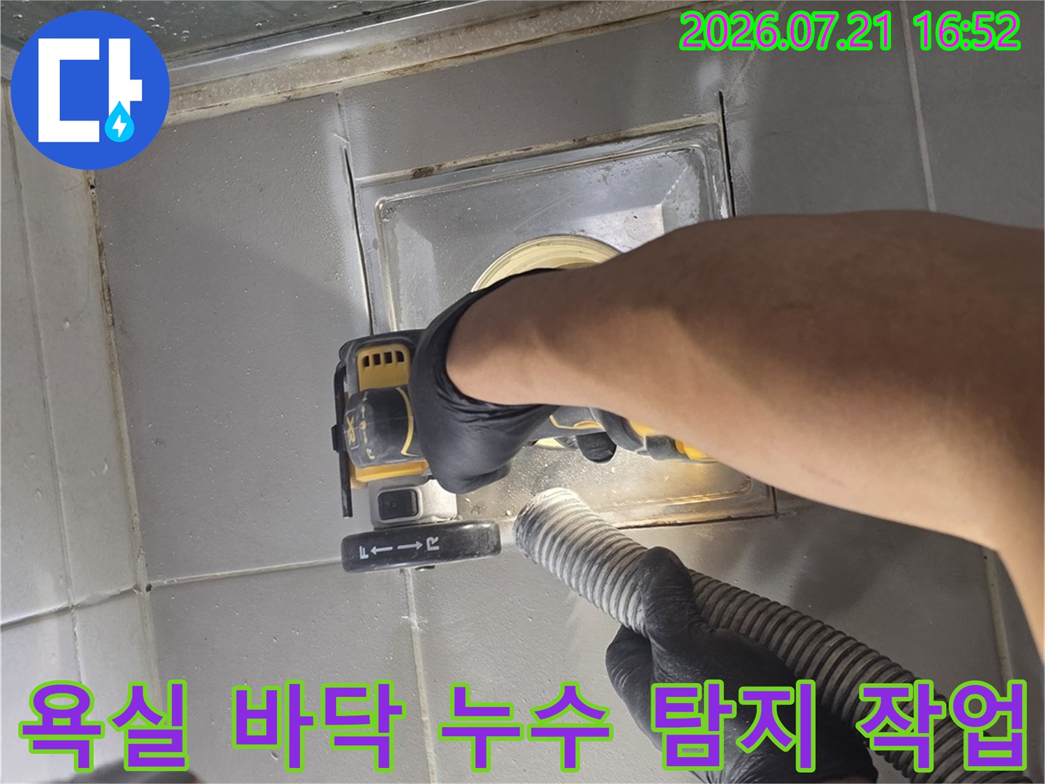 작업자가 욕실 바닥 배수구 부근에서 전문 장비를 사용하여 정밀하게 누수 지점을 점검하는 모습