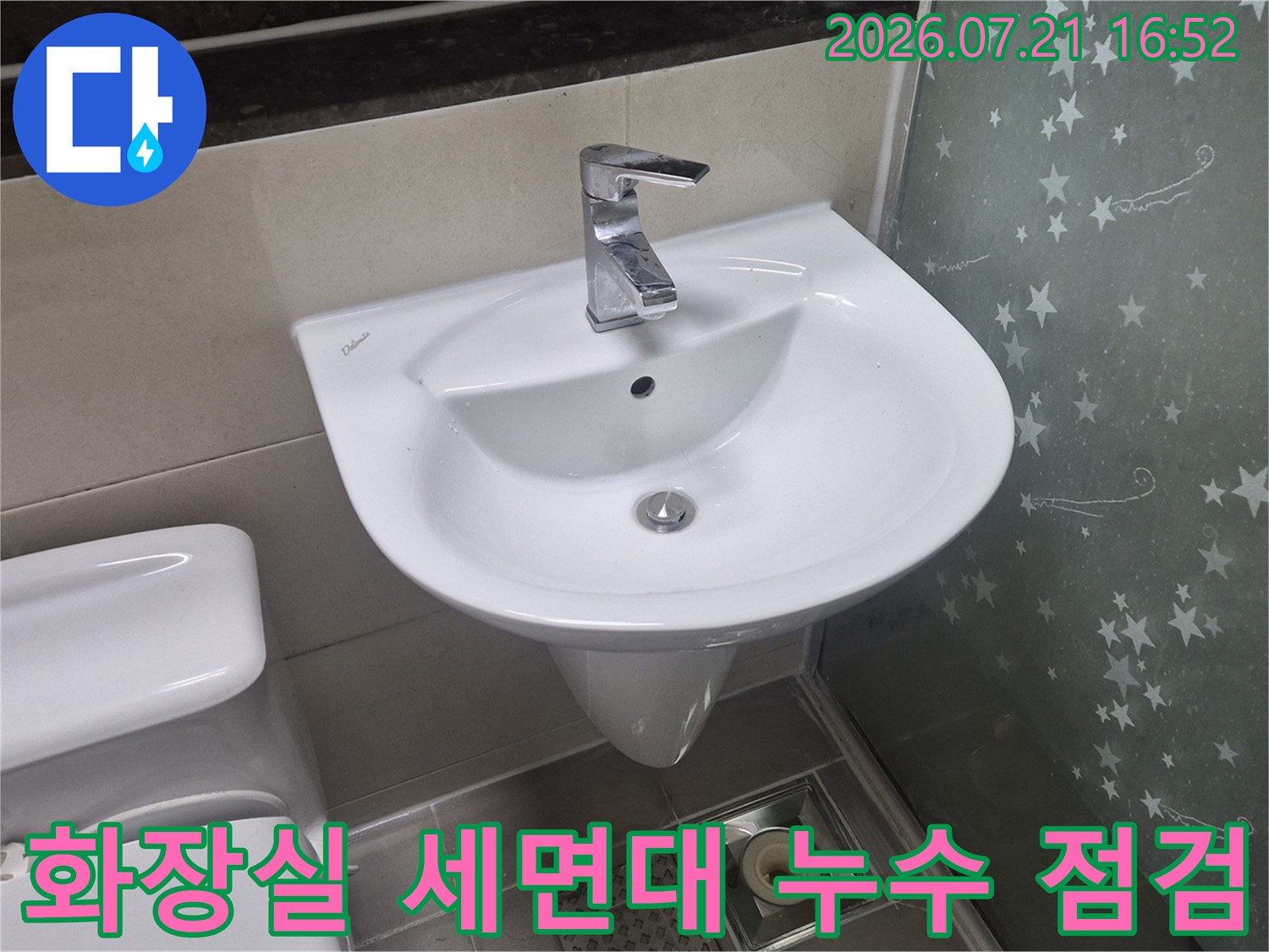 하얀색 세면대와 변기가 설치된 욕실 내부 모습