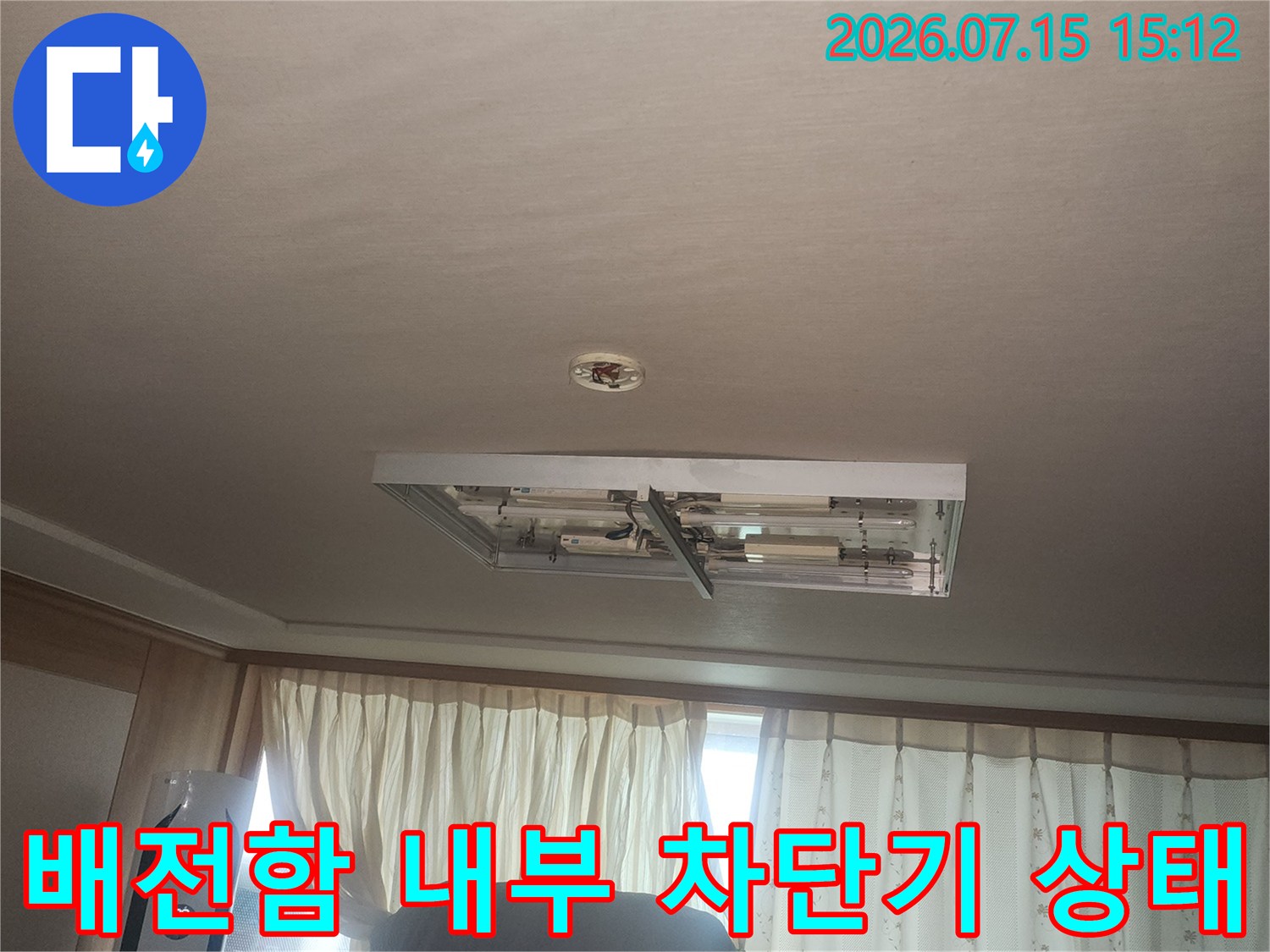 벽면에 고정된 하얀색 분전반의 커버가 열려 내부 회로가 노출된 장면