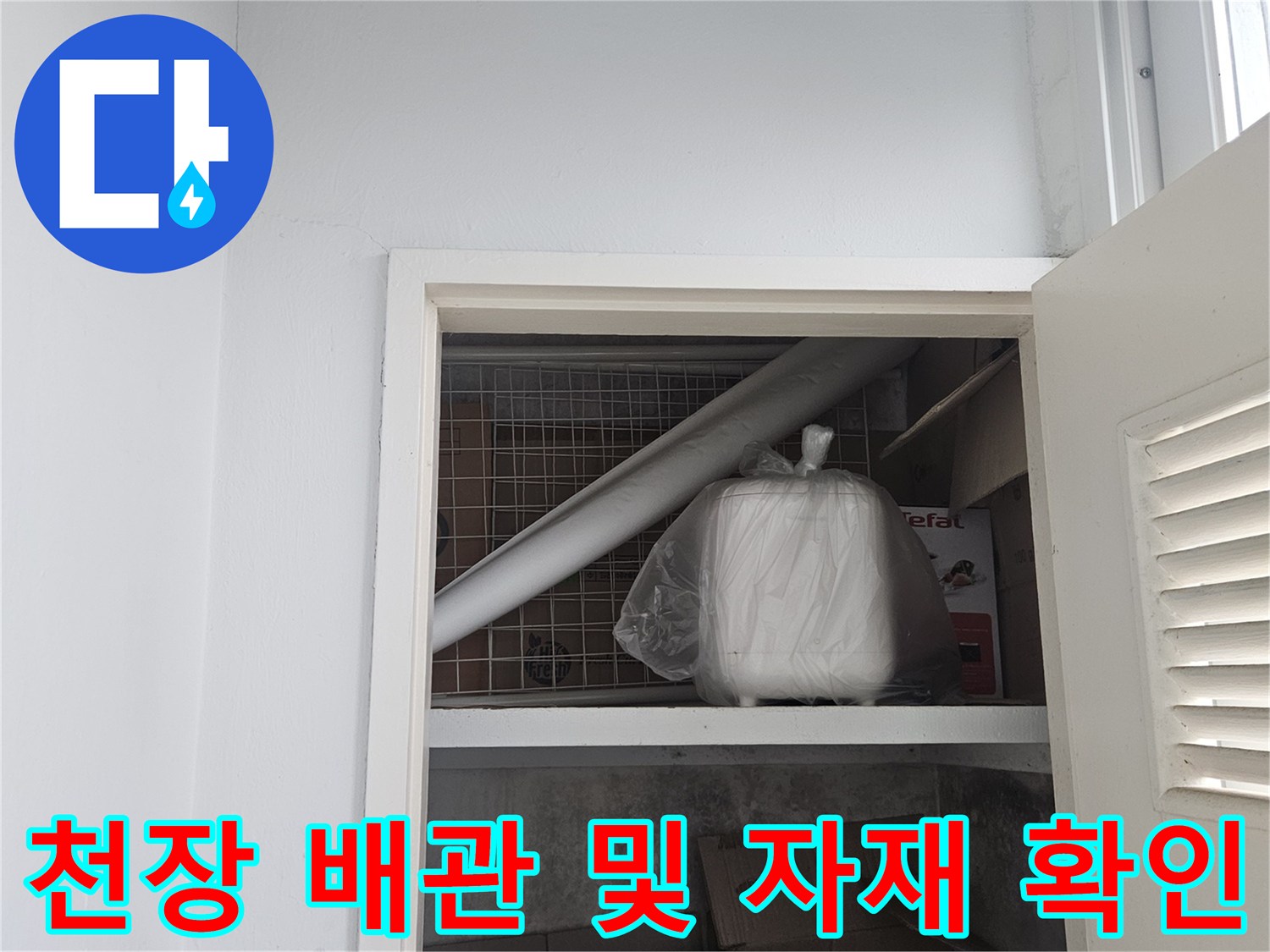 점검구를 통해 관찰한 천장 내부의 하얀색 배관과 적치물