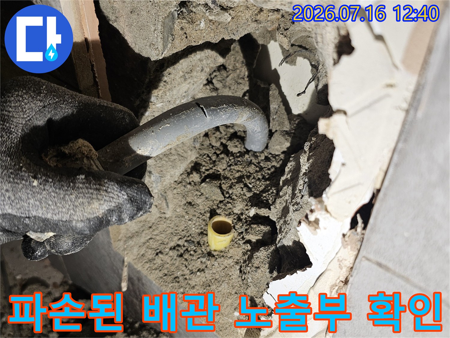 벽면 파쇄 후 드러난 배관과 주변 토사 및 습기 상태 점검 장면