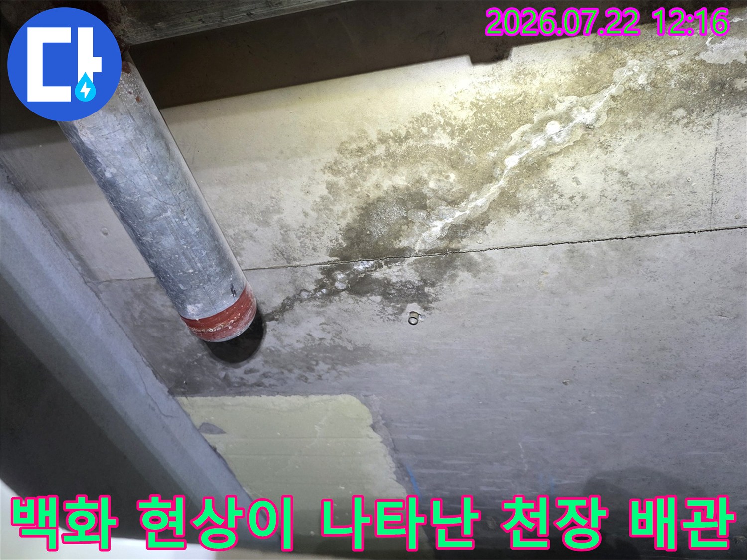 금속 배관 끝부분과 인접한 천장 콘크리트 표면의 누수 오염-사진