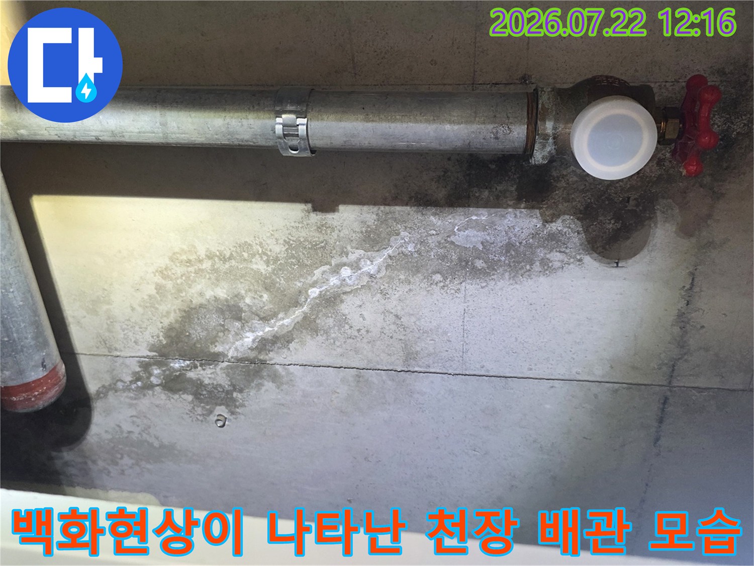 금속 배관과 밸브가 설치된 천장에서 물이 스며나와 하얗게 변색된 콘크리트 표면