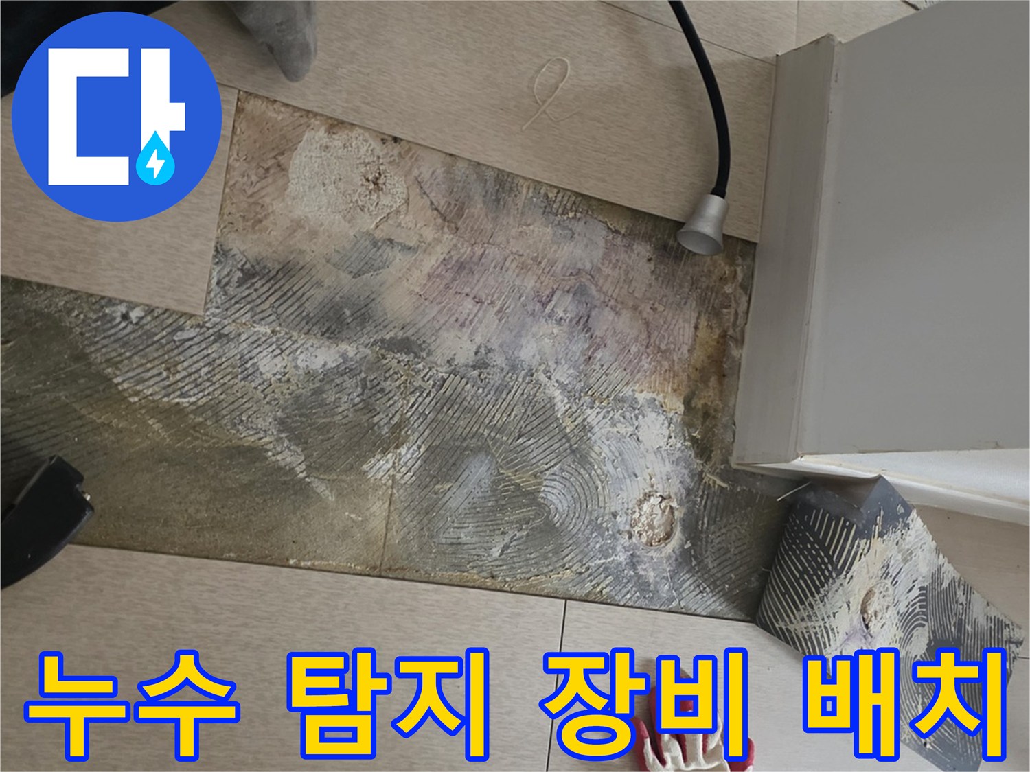 가스 탐지기와 분리된 마루 자재가 보이는 누수 작업 현장 사진
