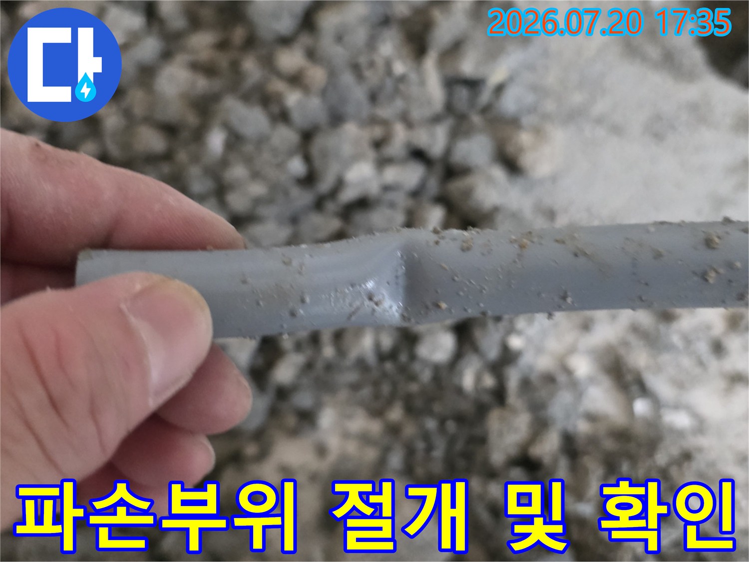 노출된 회색 배관의 파손 부위를 제거하고 상태를 점검하는 모습