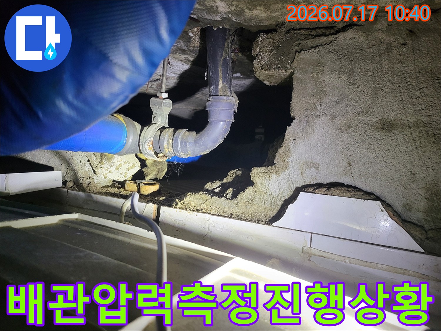 화장실 천장 점검구 내에서 파란색 호스를 활용해 배관의 누수 여부를 정밀하게 체크하는 장면
