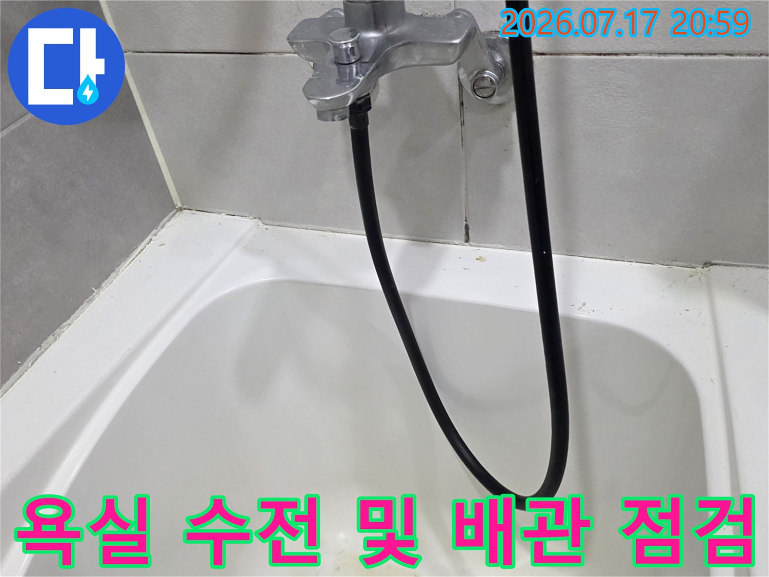 벽면에 설치된 은색 수전과 검은색 호스가 연결된 상세 모습