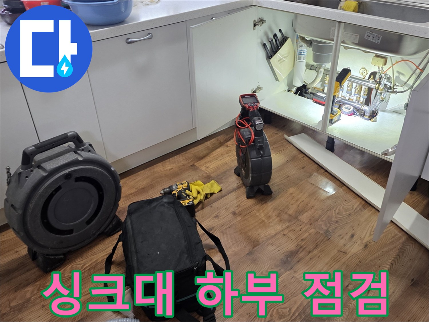 싱크대-하부장-내부-배관-점검-중인-모습