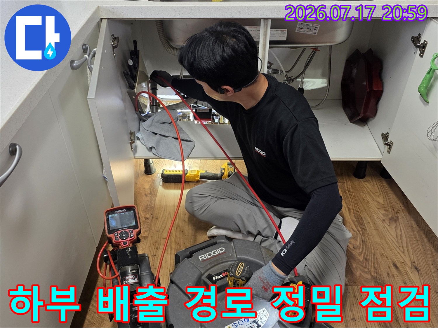 전용 장비를 사용하여 싱크대 아래 배수관의 상태를 면밀히 조사하는 모습