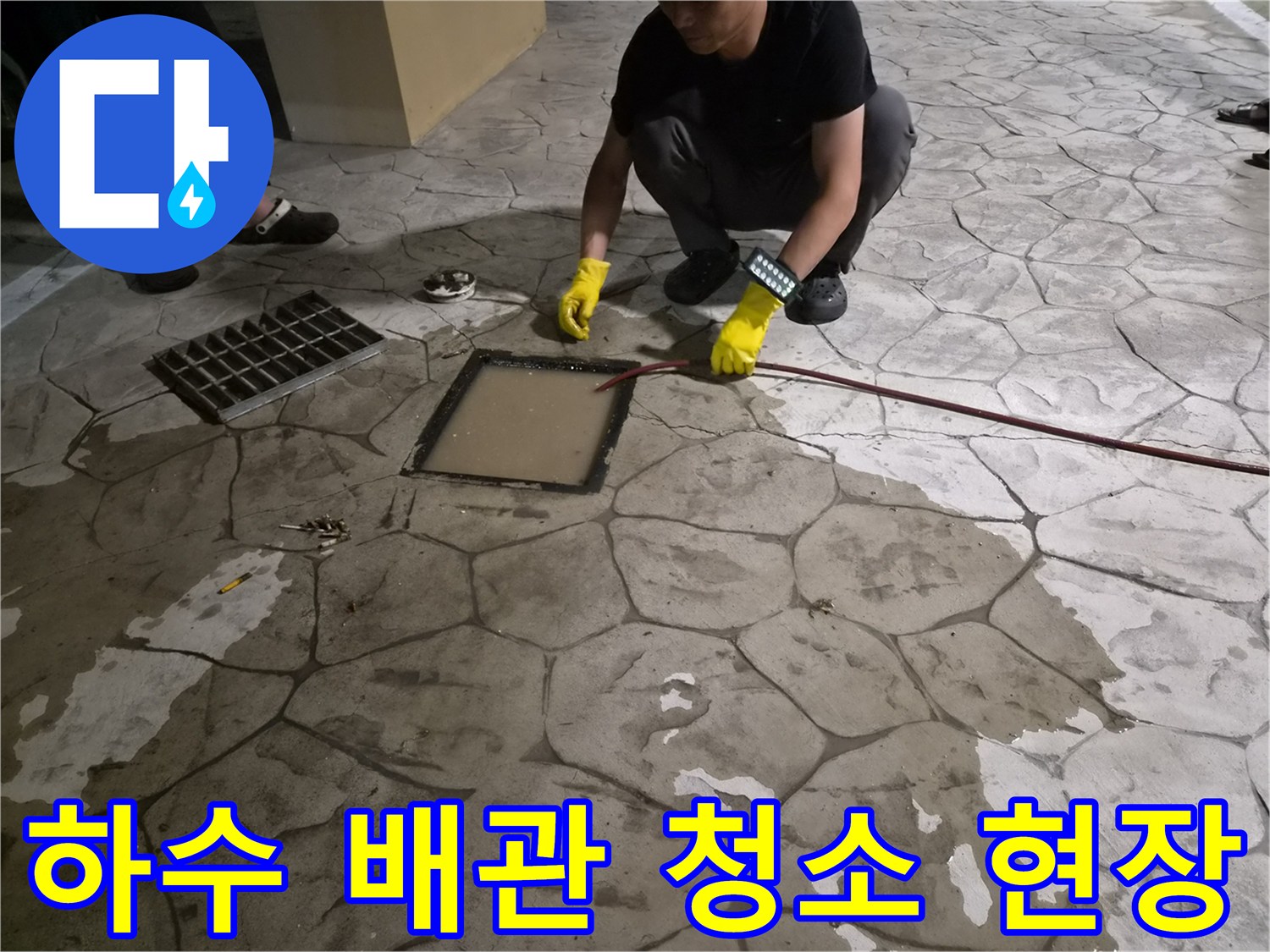 맨홀을 통해 붉은색 케이블 장비를 투입하여 관로를 뚫는 공사 과정