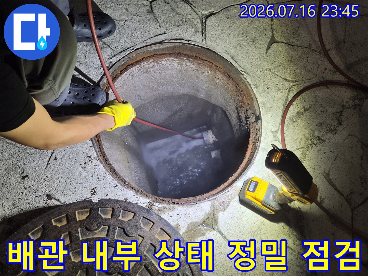 장비를 사용하여 배수구 내측의 이물질과 슬러지 퇴적 상태를 확인하는 모습
