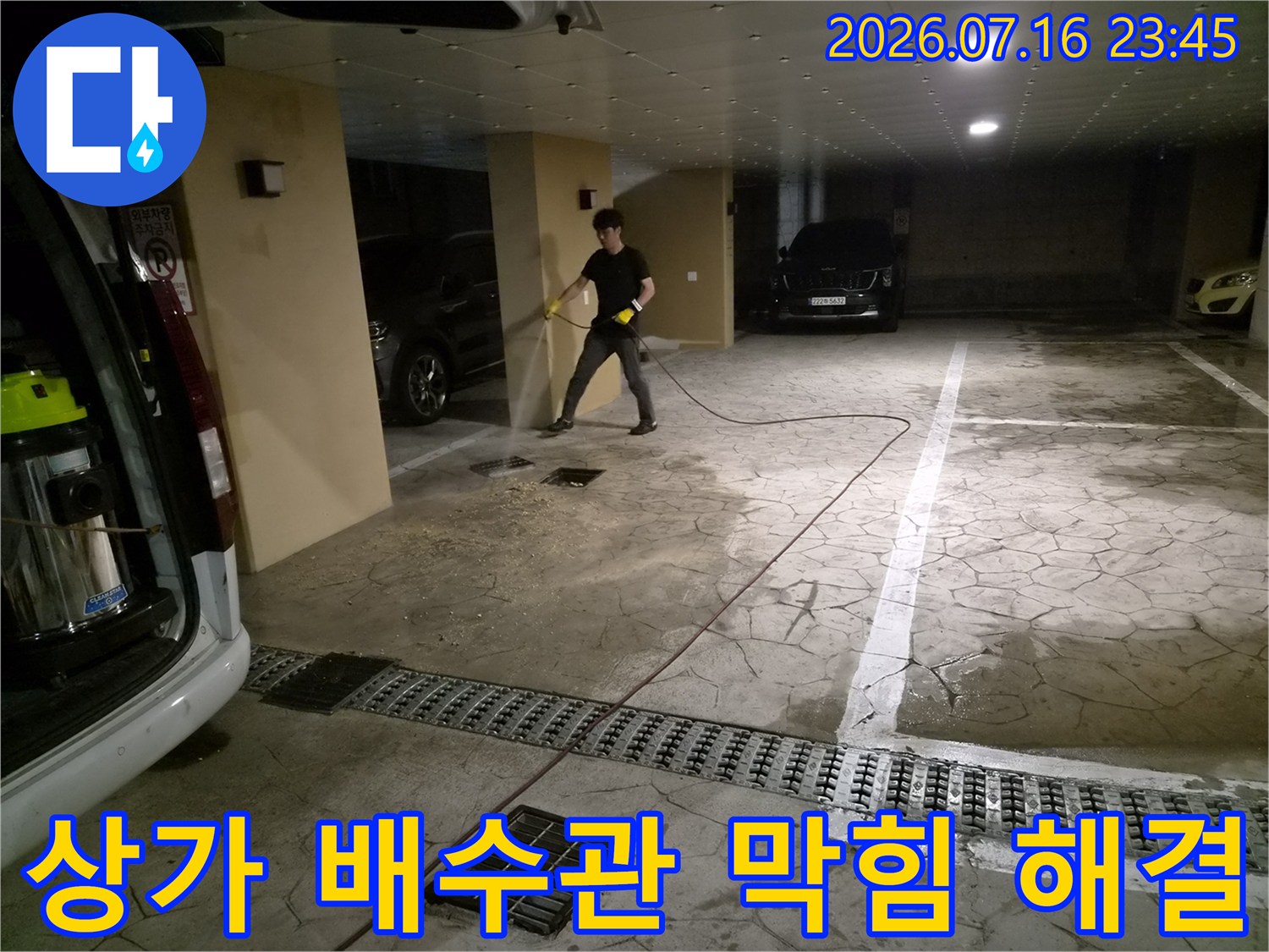 전문 장비를 활용하여 필로티 주차장 내 공용 배관의 슬러지를 제거하는 장면