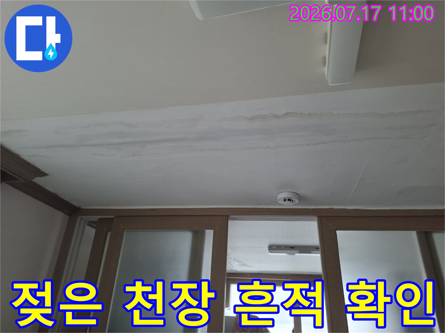 천장 마감재에 물이 스며든 자국과 젖어 있는 구간을 촬영한 사진