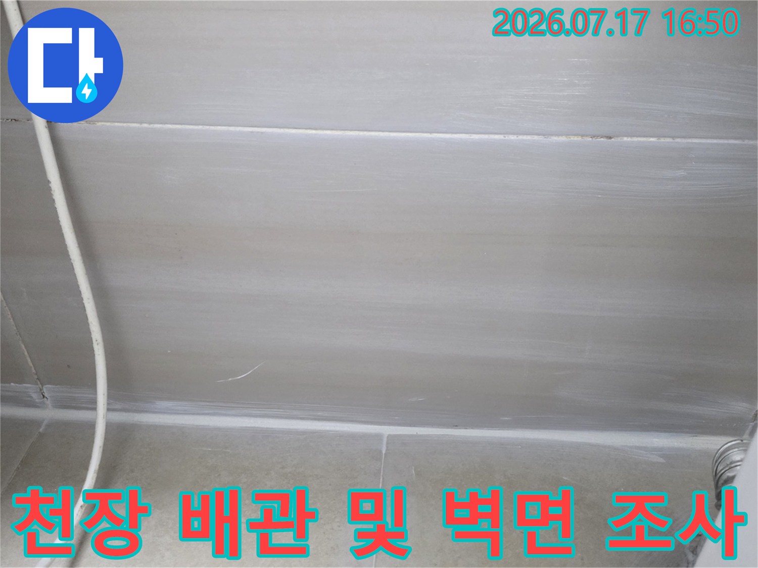천장 내부에 노출된 배관과 주변 콘크리트 상태를 점검하는 장면