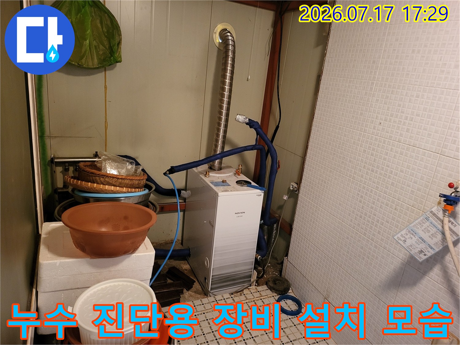 흰색 누수 탐지 장비와 파란색 호스가 연결된 배관 점검 현장