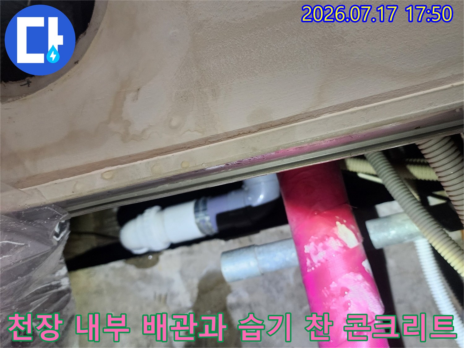 콘크리트-천장에-형성된-물-얼룩과-분홍색-보온재가-씌워진-배관-사진