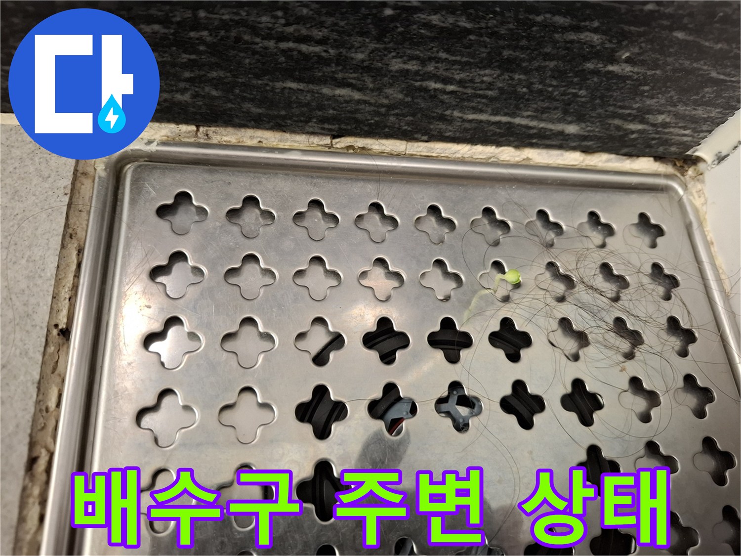 스테인리스 배수구 덮개와 주변 타일 상태를 보여주는 사진입니다.