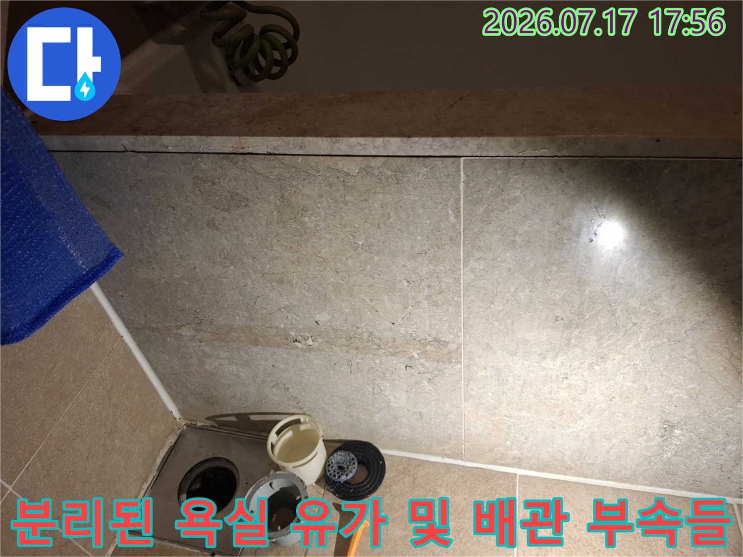 스테인리스-배수구-입구와-그-옆에-나열된-흰색-플라스틱-하수구-부품들의-사진