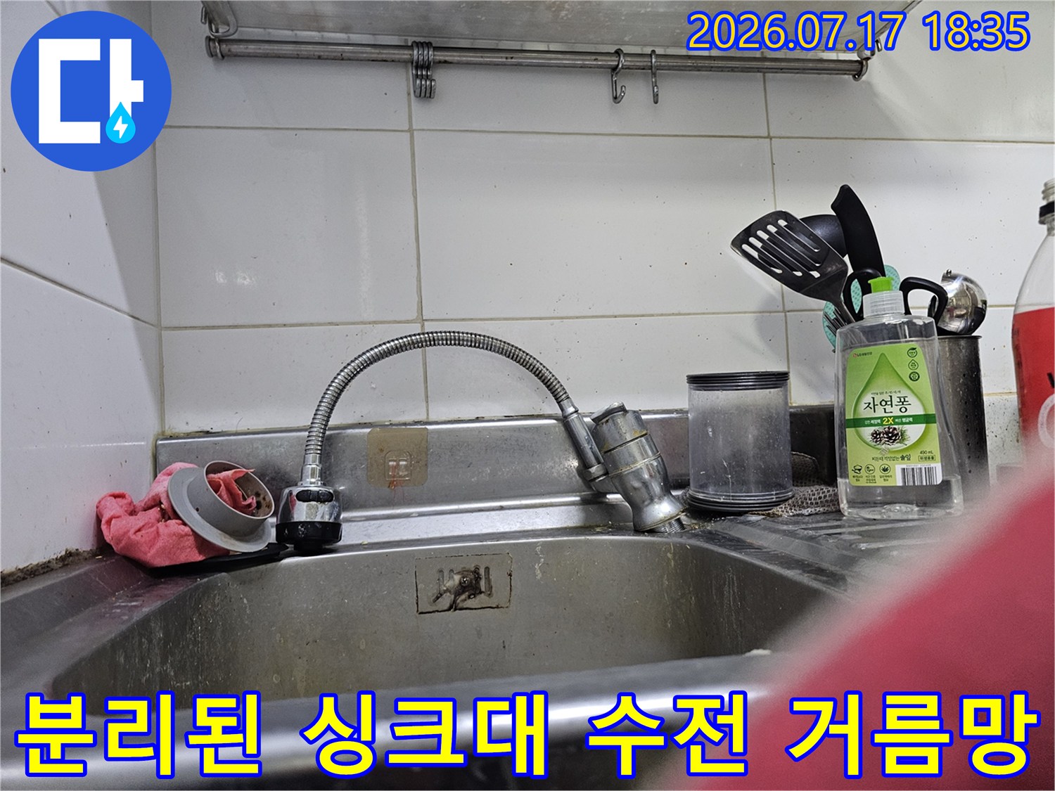 주방 싱크대 수전에서 분리되어 놓여 있는 금속제 거름망-필터 부품 사진