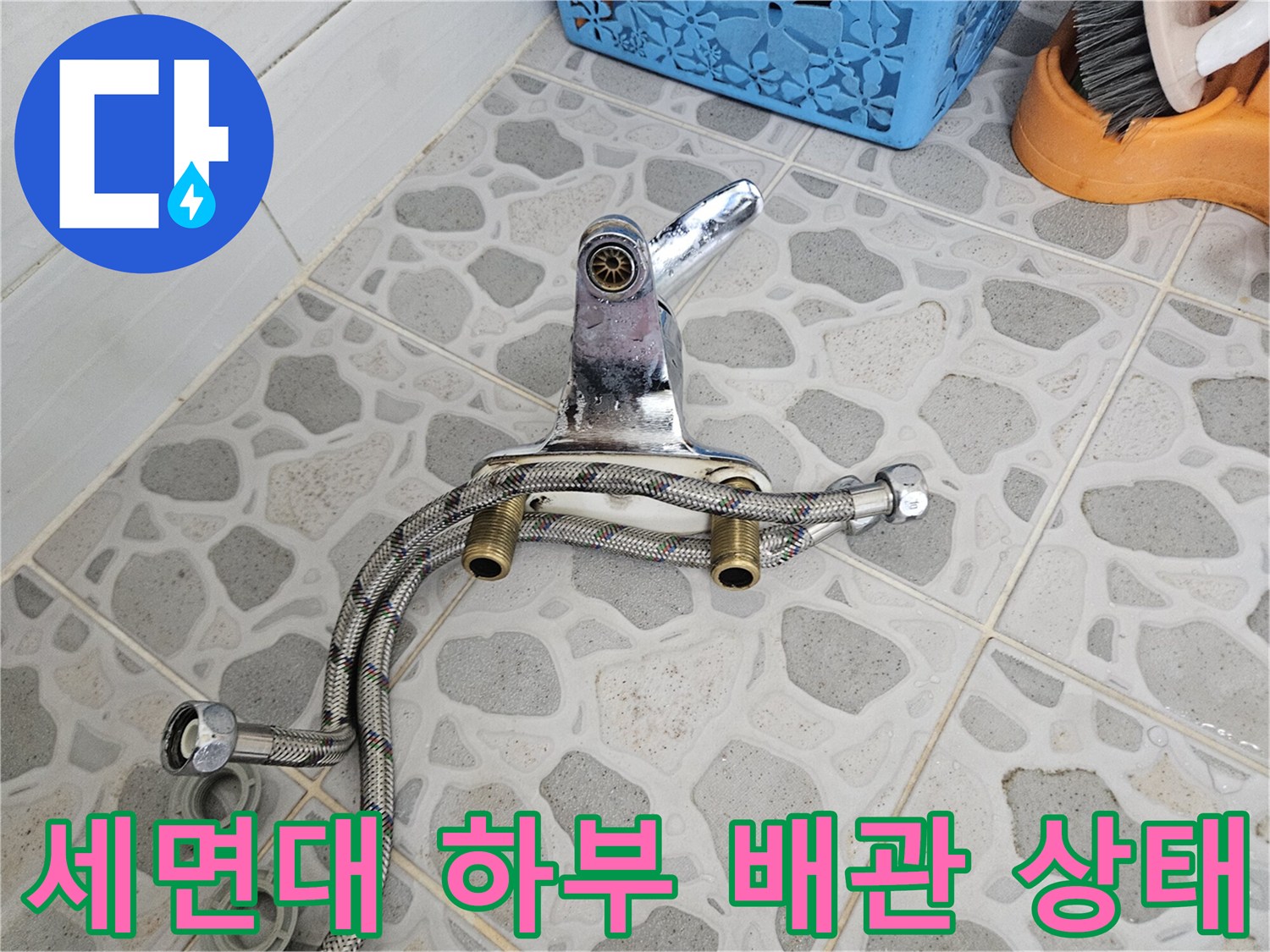 세면대-하부-연결된-금속-자바라-호스와-수전-부분의-근접-사진입니다.
