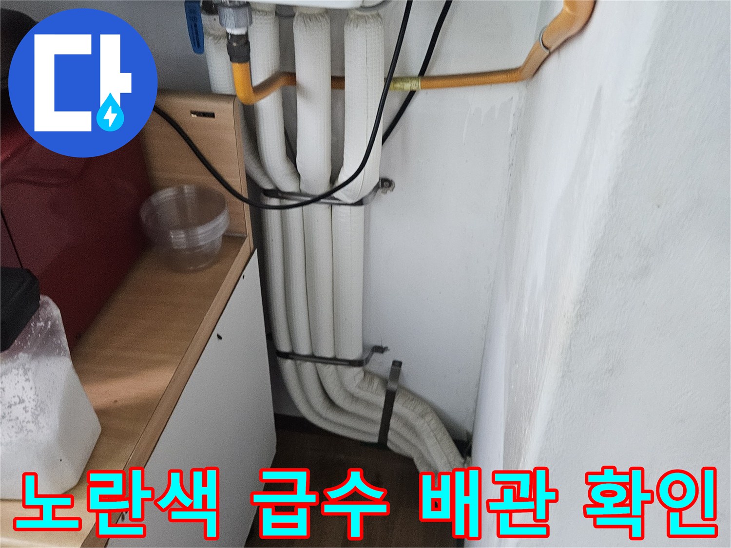 세탁실-벽면-노란색-급수관과-하얀색-배수파이프-근접 촬영