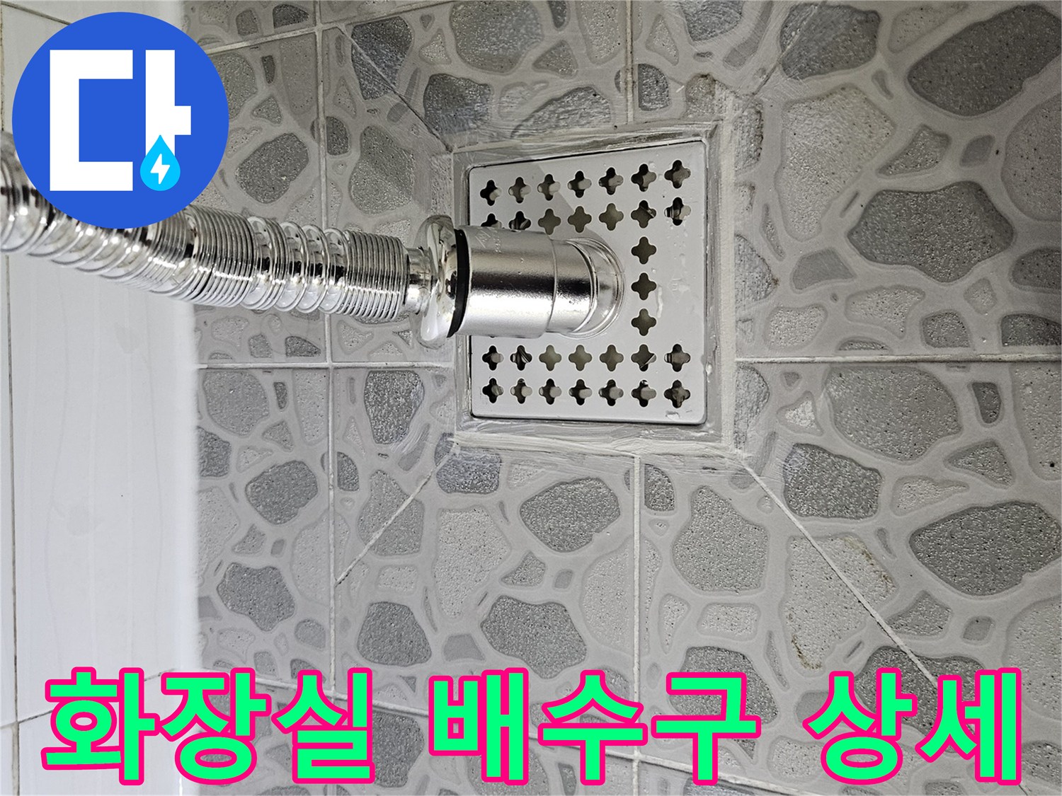 은색 샤워기 부속과 타일로 된 화장실 배수구 유가 근접 촬영