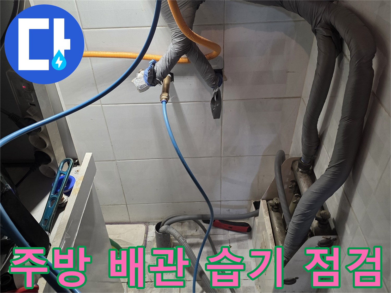 보온재로 감싸진 배관과 주변 타일의 습기 상태를 보여줍니다.