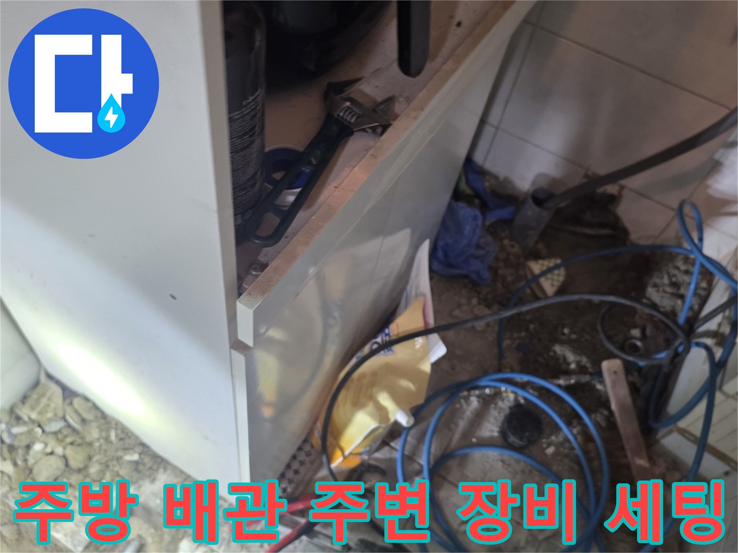 싱크대 아래 배관 점검을 위해 배치된 각종 측정 및 작업 도구들입니다.