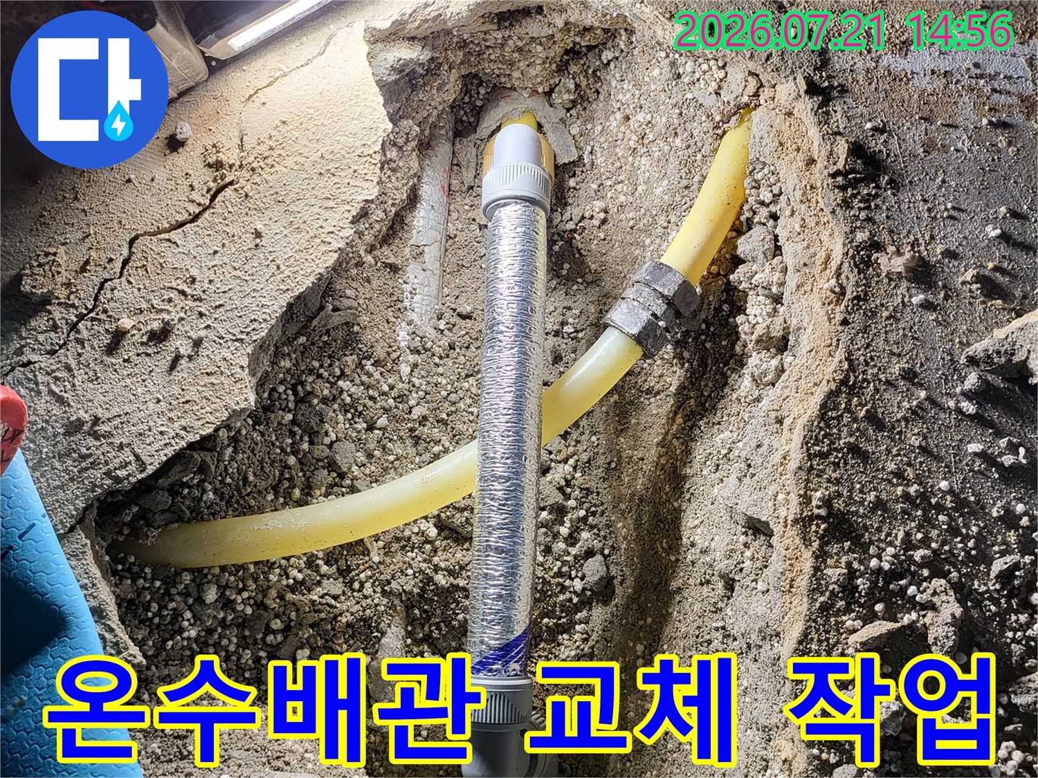 노란색 온수배관과 은색 보호재가 덮인 배관 연결 부위의 굴착 현장