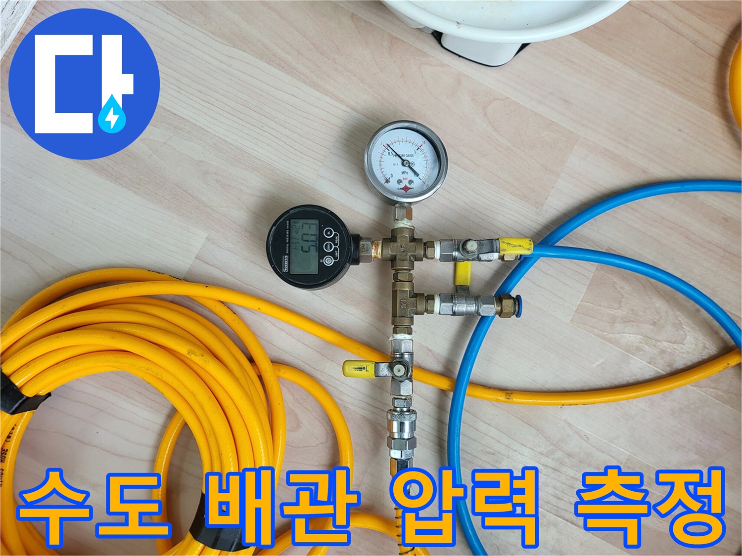 노란색과 파란색 호스가 연결된 배관 압력 테스트 장비