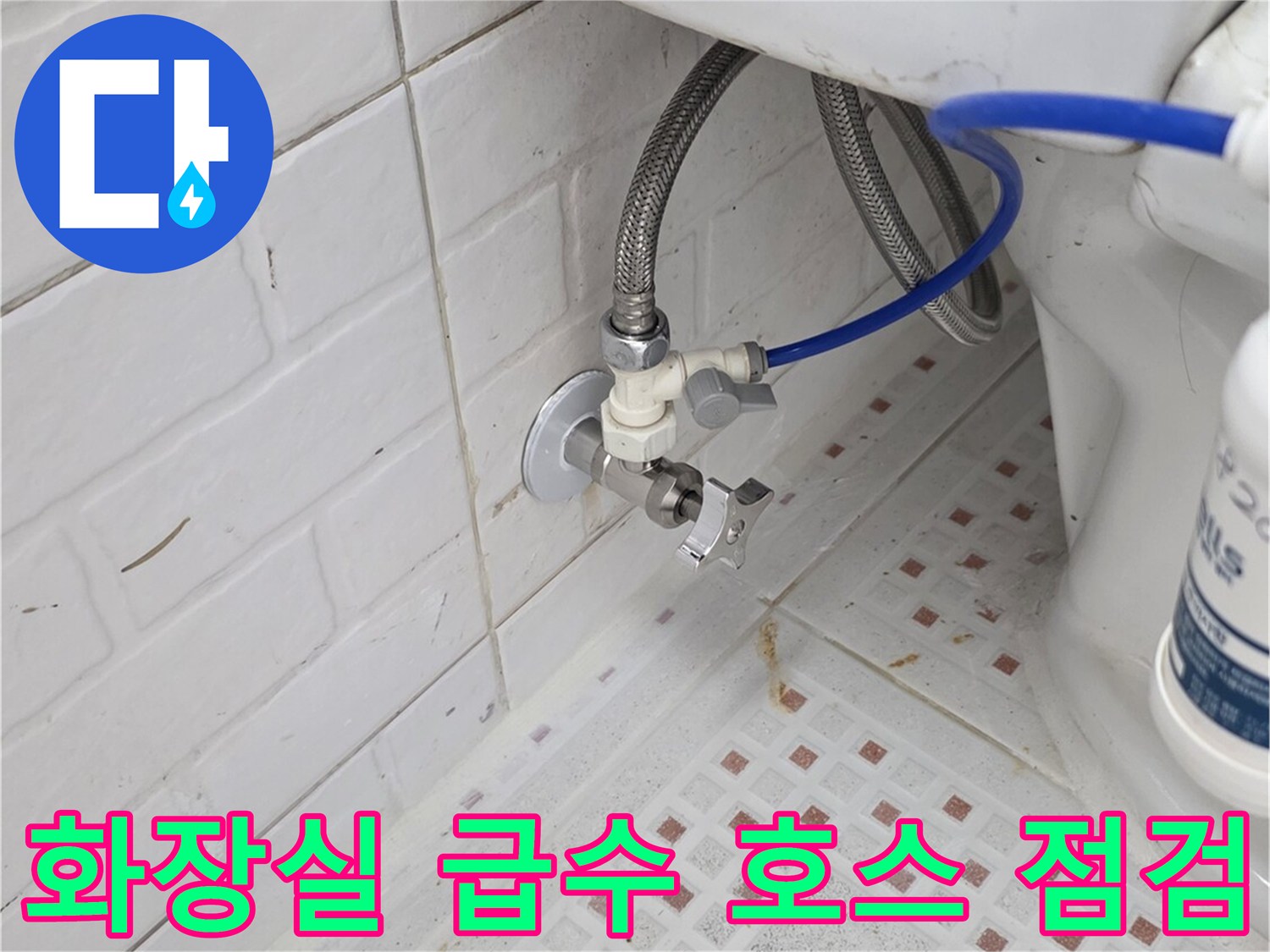 화장실 변기에 연결된 파란색 호스와 쇠로 된 유연한 배관
