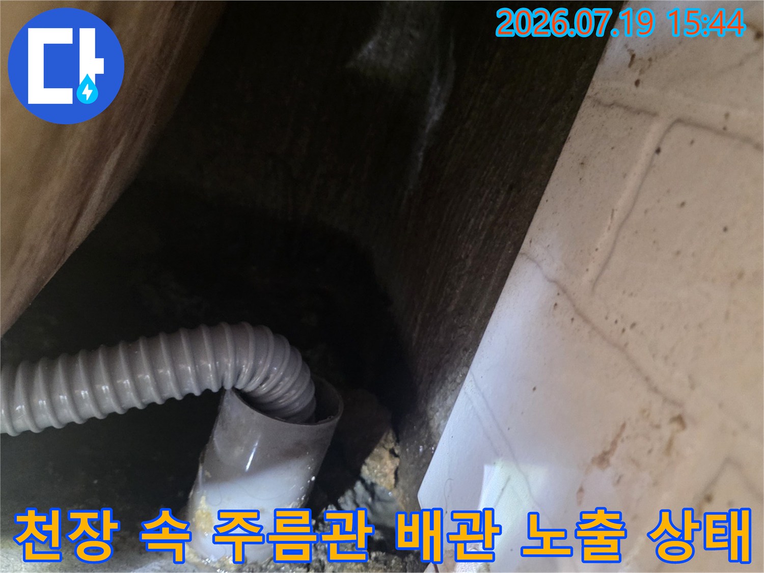 화장실-천장-내부에-설치된-회색-주름-배수관과-천장면