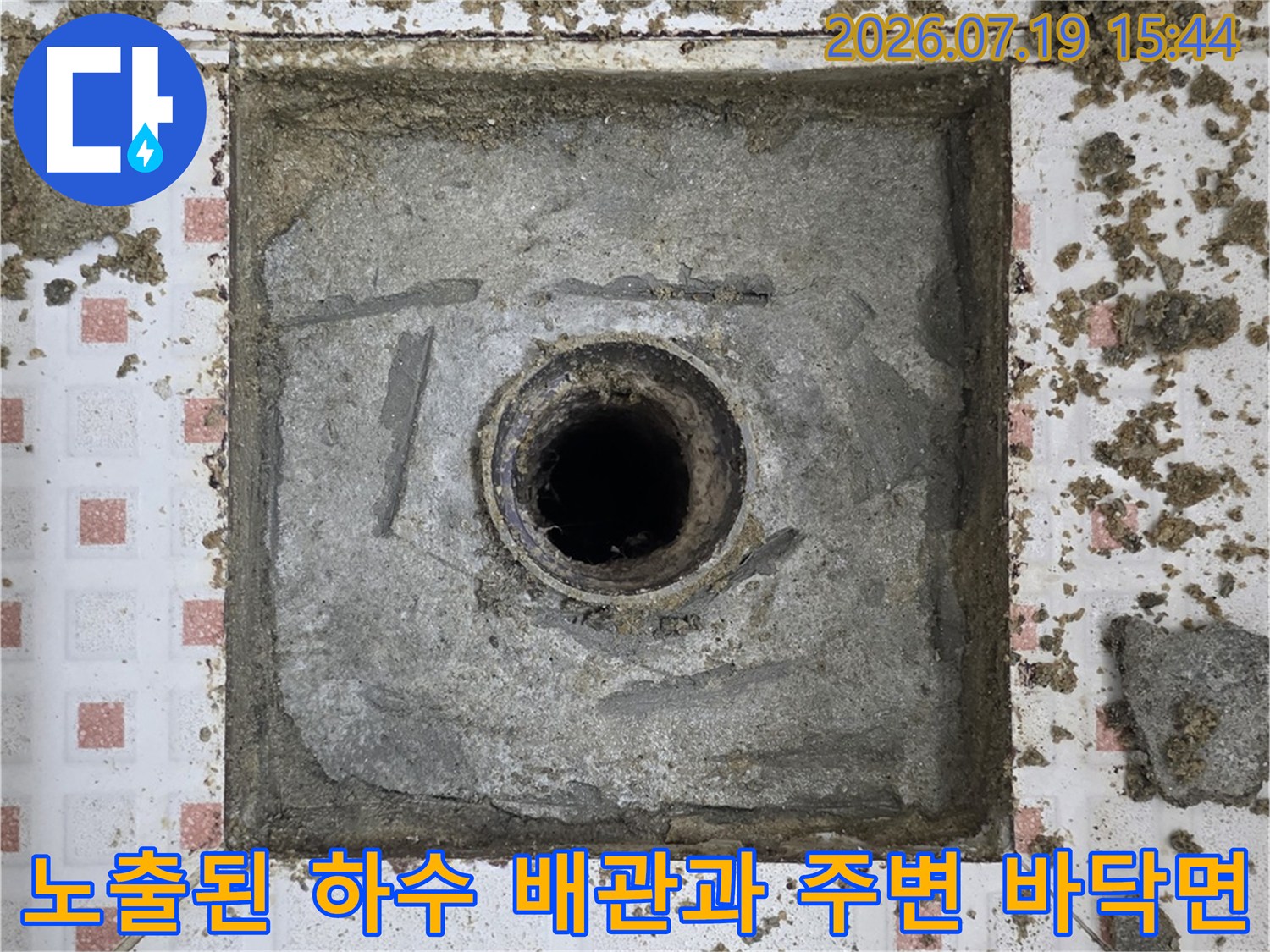 회색-콘크리트-바닥에-중앙-배수구가-위치한-화장실-내부-현장-사진