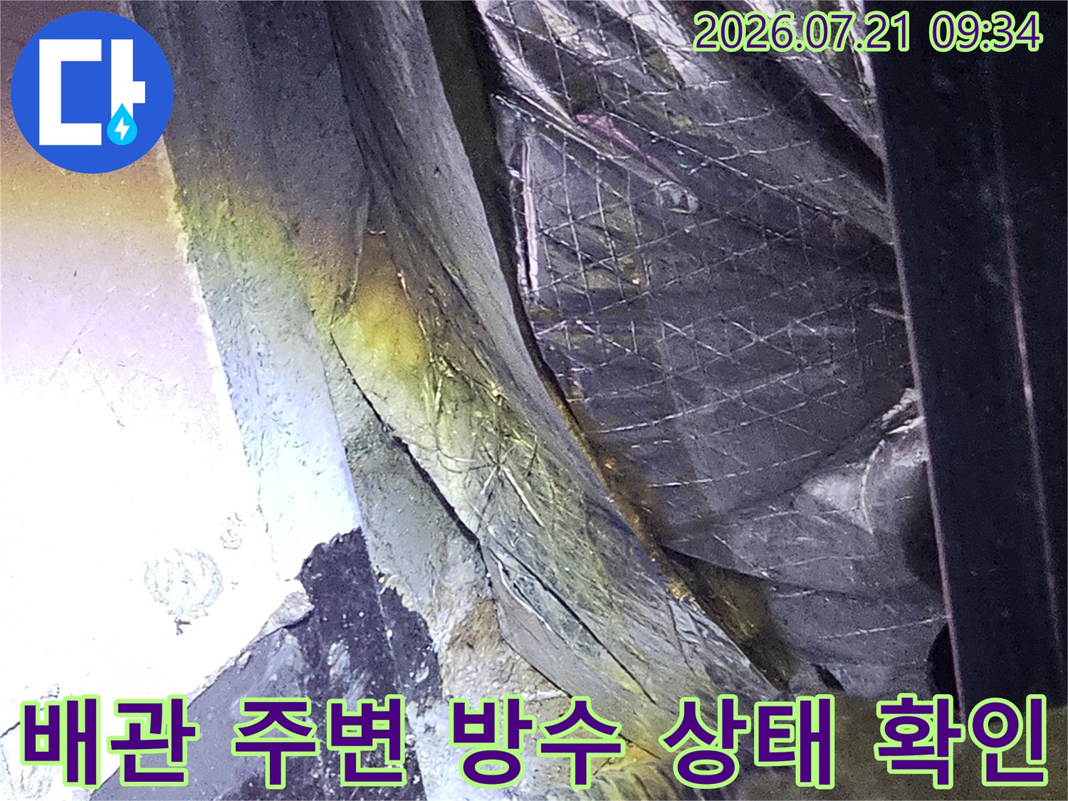 천장 배관과 구조물 사이의 수분 침투 경로를 면밀히 검사하는 모습
